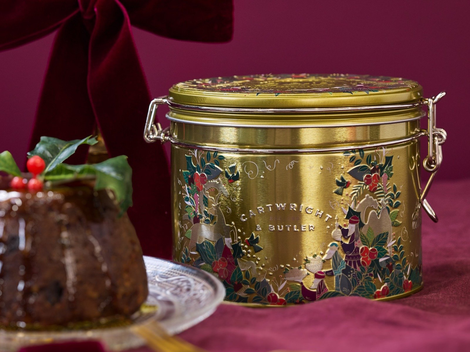 Gold round tin for chirstmas pudding with christmas pudding slightly out of focus
