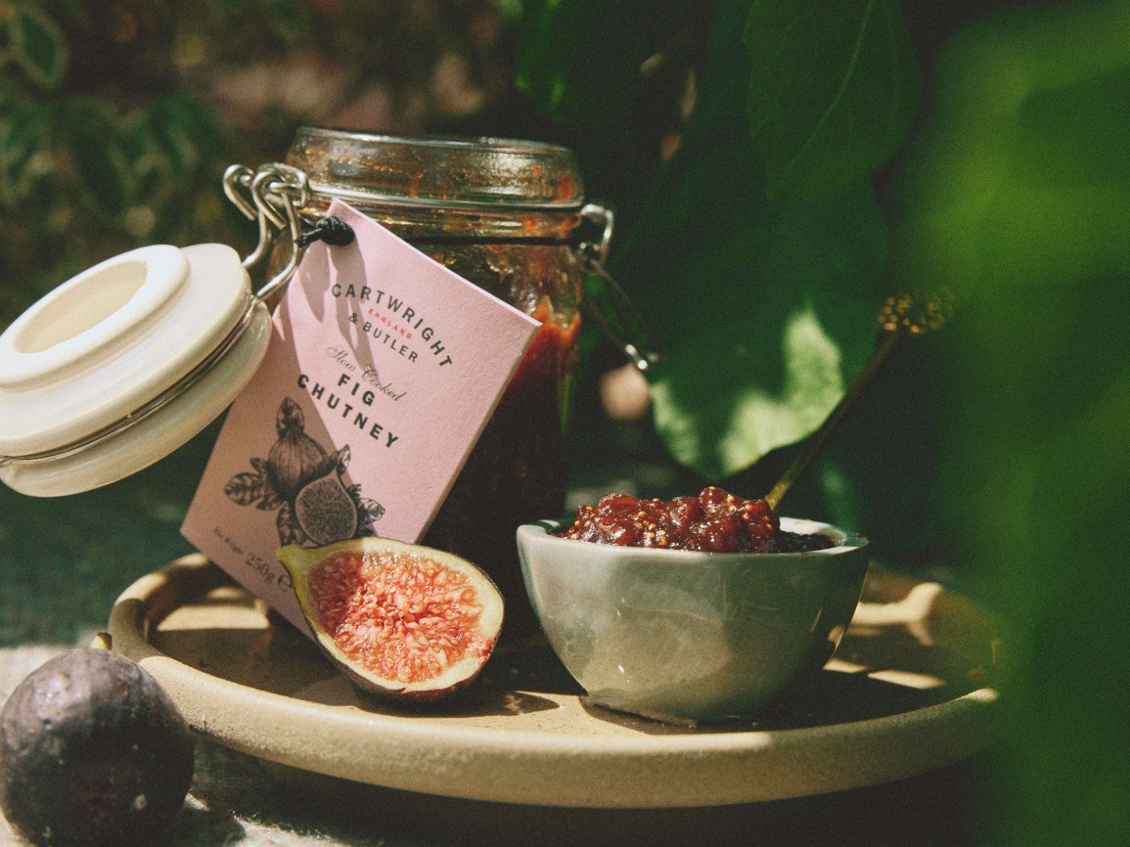 fig chutney, glass jar with open lid, pot of chutney in a small bowl with figs