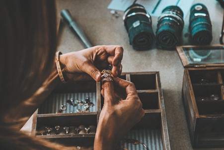 Woman using jewellery box and placing rings on finger