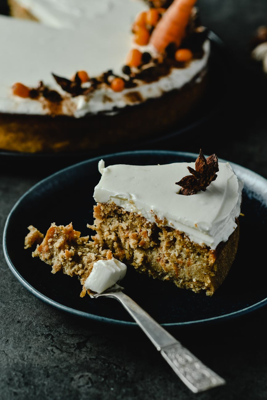 Slice of carrot cake sitting on black plate