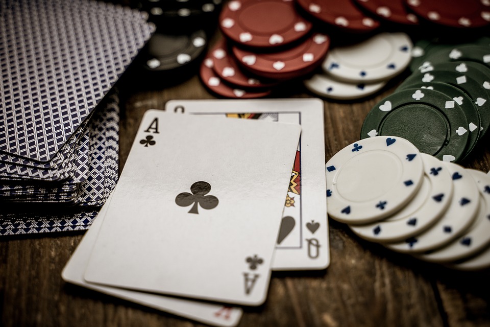 Ace and other cards on the table with gambling coins