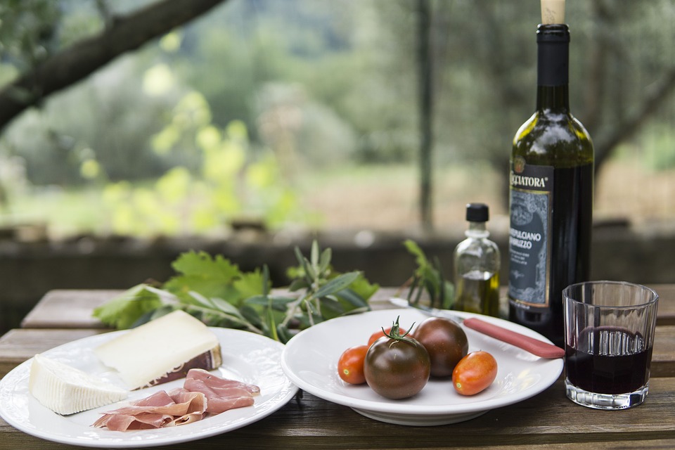 Cheese and ham board and bottle of wine outside