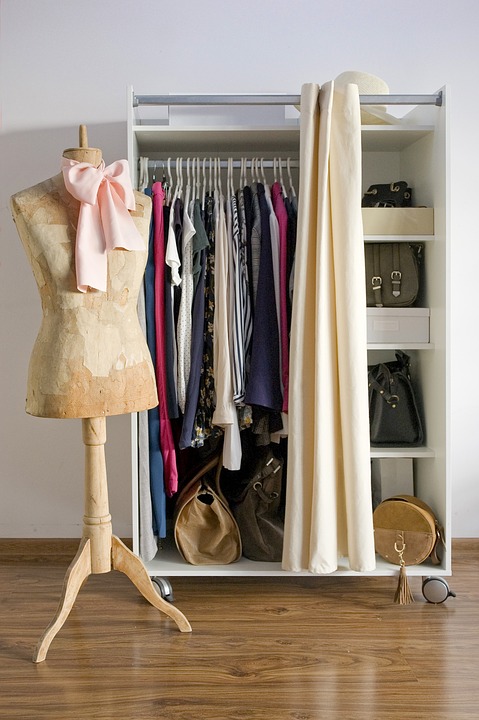 Open wardrobe with clothes hanging and stored bags