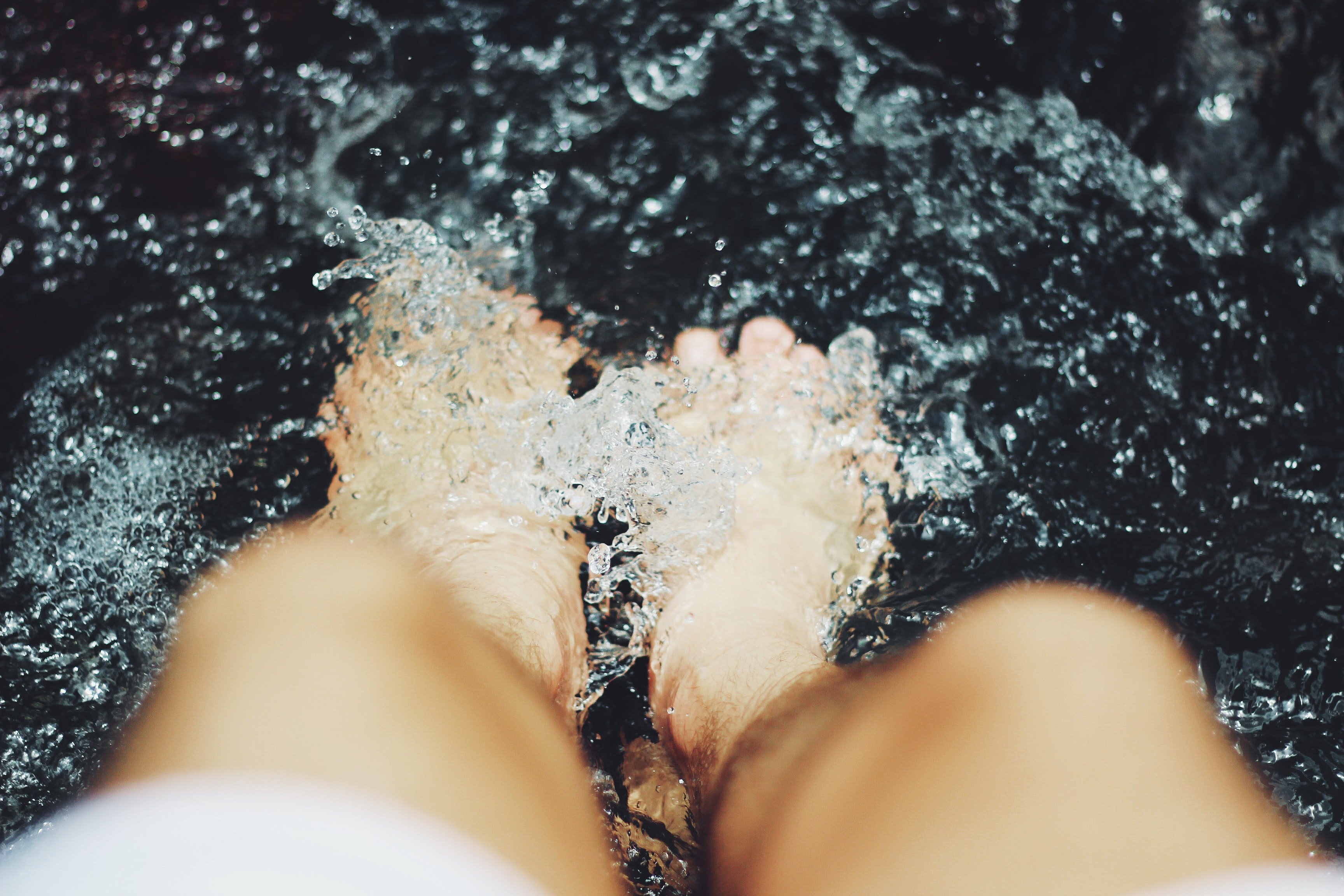 Person soaking toes in bubbly foot spa