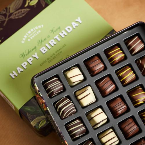 Dark, Milk and White Chocolates shown in tray with a gift sleeve showing Happy Birthday Message