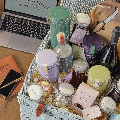 Corporate Gifting - Picture of Laptop with company logo next to a selection of luxury hamper gift products